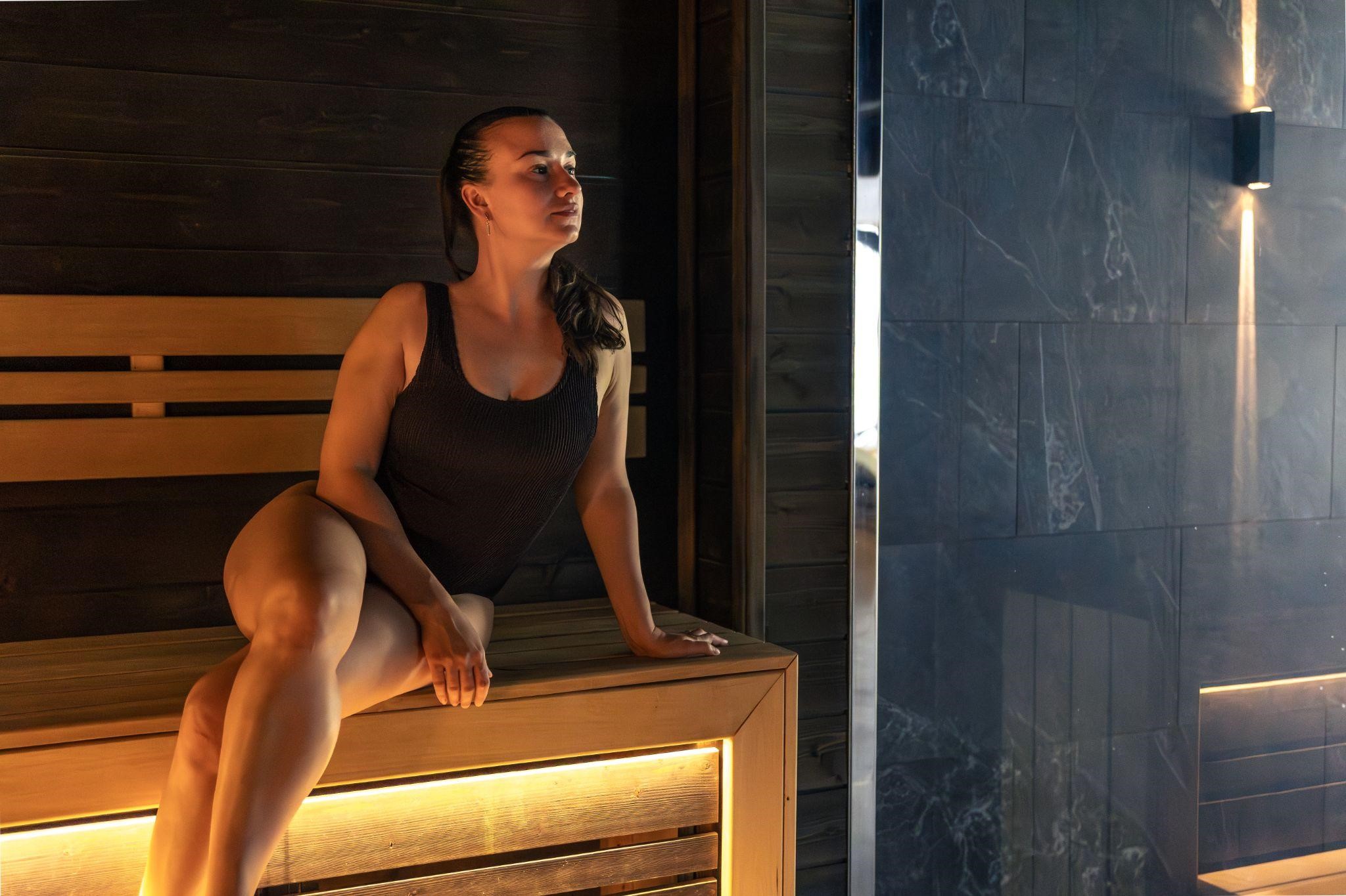 Woman relaxing in custom outdoor sauna for home wellness